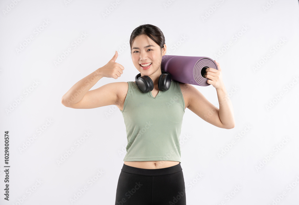Portrait of young Asian girl wearing sports clothes, headphones and posing on white background Portrait of young Asian girl wearing sports clothes, headphones and posing on white background
