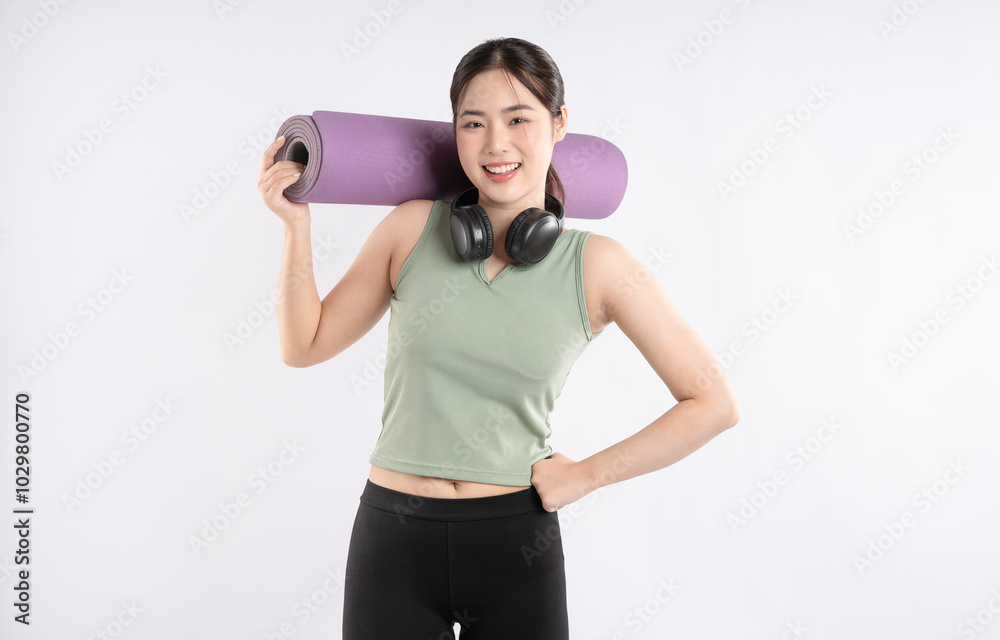 Portrait of young Asian girl wearing sports clothes, headphones and posing on white background Portrait of young Asian girl wearing sports clothes, headphones and posing on white background
