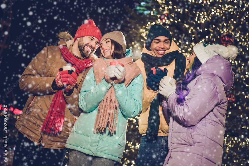 Obraz premium Portrait of group peaceful cheerful fellows hold hot chocolate coffee cup have good mood evening magic outside