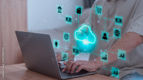 Person using a laptop while various digital icons, representing cloud computing, financial technology, and data management. Concept of cloud service and interconnect digital tools in modern business.