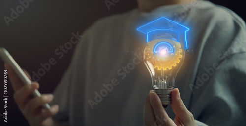 Apprentice concept, a person who is undergoing apprenticeship training in pursuance of a contract of apprenticeship. Woman holding lightbulb to show gear with graduation hat icon on virtual screen. photo