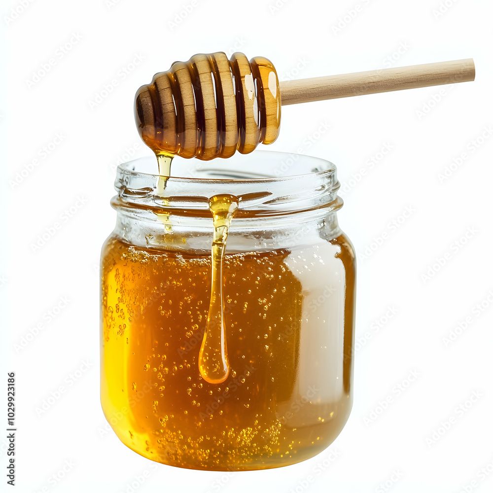 A wooden honey dipper with dripping honey is held over a glass jar filled with golden honey. A wooden honey dipper with dripping honey is held over a glass jar filled with golden honey.