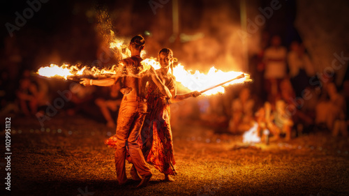 The enchanting fire dancers beautifully showcase their talent with fascinating flames during the performance.