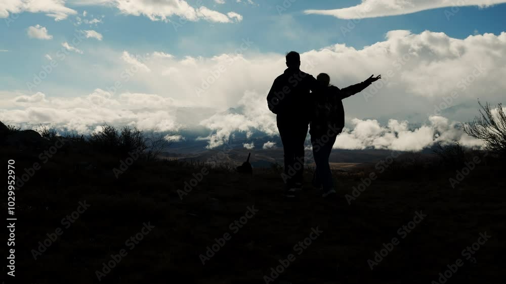 custom made wallpaper toronto digitalSilhouettes of two tourists in love, a man and a woman, hugging and walking to the top of the mountain. A man hugs a girl. Travel and mountain tourism concept. Hiking in the wild.