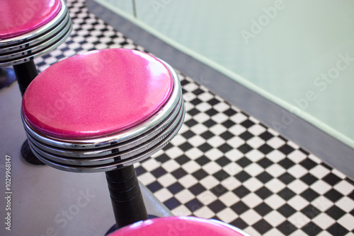 Magenta stools checkered floor in retro diner photo