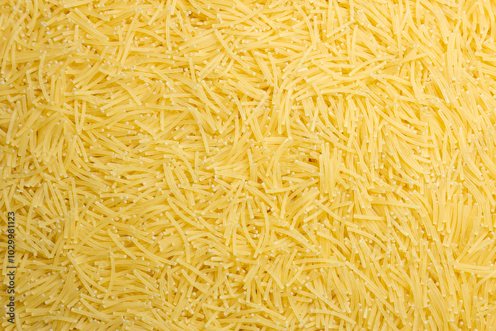 Obraz premium Uncooked Filini Pasta: A Culinary Canvas of Noodles, Creating a Lively and Textured Background for Gourmet Cooking. Dry Pasta. Raw Macaroni - Top View, Flat Lay