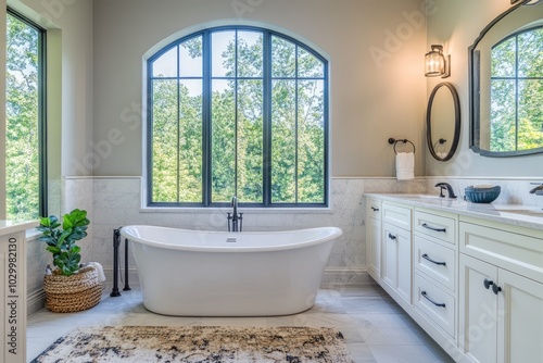 Modern bathroom featuring freestanding tub and large window overlooking nature photo