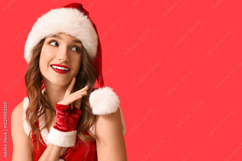 Young woman in Santa Claus costume on red background Young woman in Santa Claus costume on red background