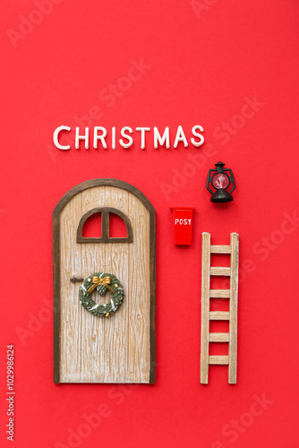 Beautiful composition with door, ladder and Christmas decorations on red background