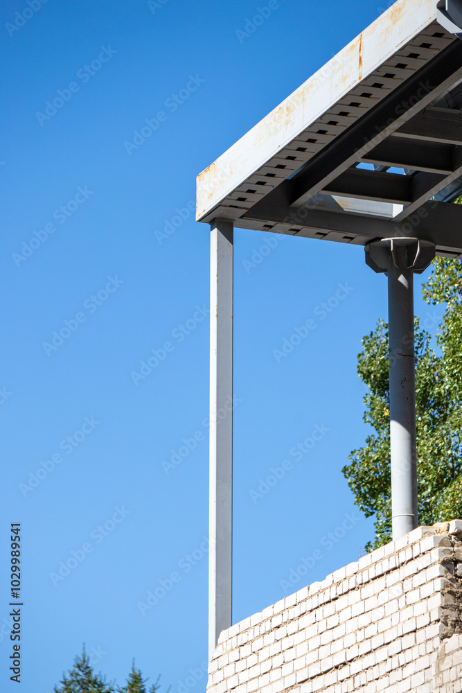 A metal pole is leaning against a building A metal pole is leaning against a building