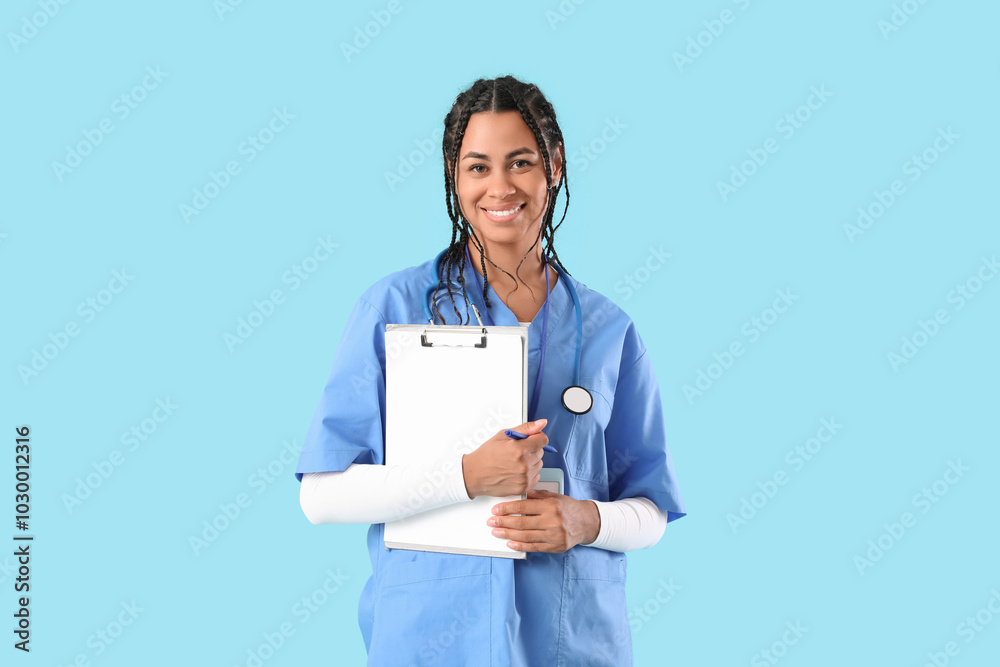 Young African-American female doctor with stethoscope and clipboard on blue background Young African-American female doctor with stethoscope and clipboard on blue background