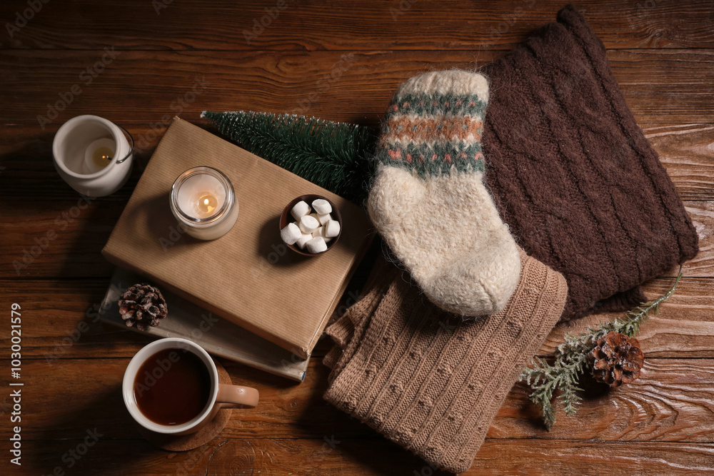 Fototapeta premium Cozy winter evening with hot chocolate, marshmallows, books, and knitted warmth on rustic wooden table