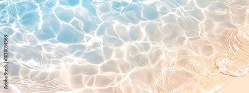 transparent rippled water surface at the sand beach on a summer day, abstract idyllic beach vacation background, copy space. Beautiful beach with blue sea, waves on the sand seen from above. Top view.