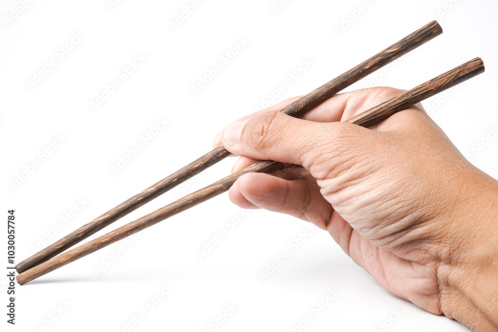 Close-up photo of Someone hand is holding wooden chopsticks to pick some food isolated on white background. High angle, Flat Lay Setup. Close-up photo of Someone hand is holding wooden chopsticks to pick some food isolated on white background. High angle, Flat Lay Setup.
