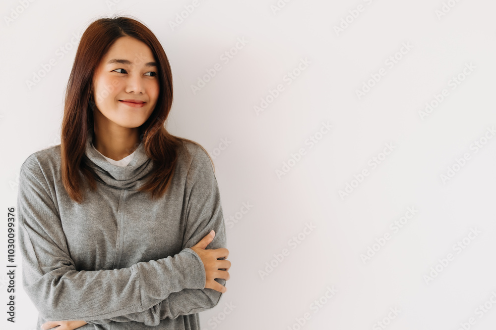 Happy beautiful asian Thai woman wear grey sweater, smiling while standing isolated over white wall in winter. Happy beautiful asian Thai woman wear grey sweater, smiling while standing isolated over white wall in winter.