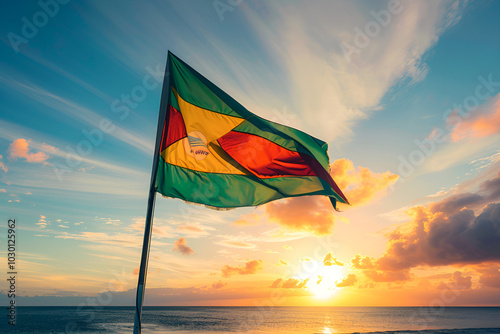 A flag with green, red, and yellow stripes waving in the wind at sunset.