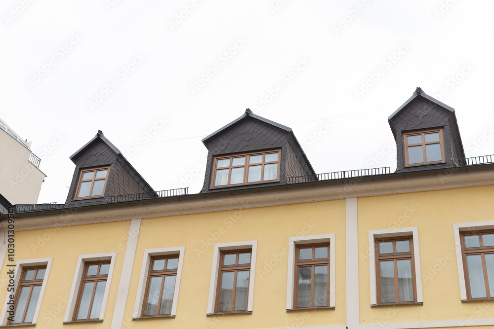 There is a bright yellow building that features numerous windows throughout its exterior, giving it a lively appearance and charm There is a bright yellow building that features numerous windows throughout its exterior, giving it a lively appearance and charm