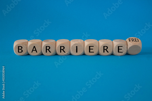 Obraz na płótnie Turned a dice and changes the German word ‘Barriere’ (barrier) to ‘Barrierefrei’ (barrier free). Beautiful blue background. Business, psychological concept. w salonie