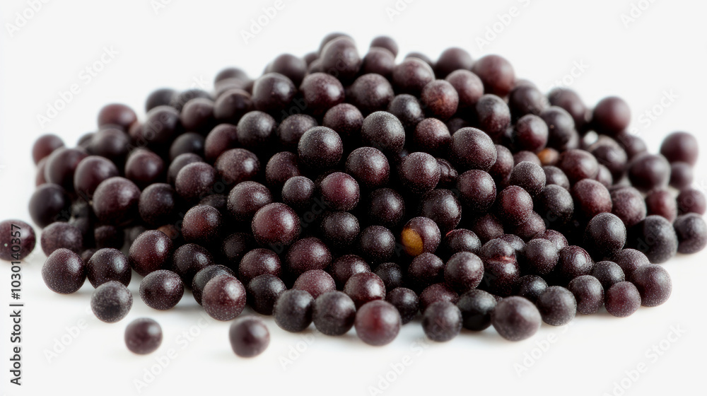A heap of whole black mustard seeds with their tiny, round shape, scattered on a white background A heap of whole black mustard seeds with their tiny, round shape, scattered on a white background