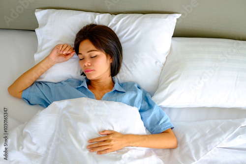 Woman peacefully sleeping in bed on her back