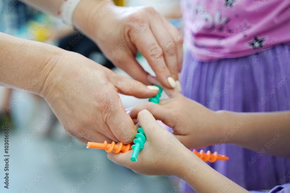 Fototapeta premium children's hand and teacher hand in the classes of developmental