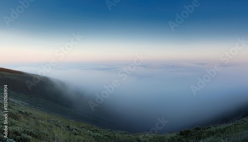 Frosty Winter Dawn Over a Misty Valley. Ethereal Landscape of Frost Covered Fields and Bare Trees Shrouded in Morning Fog, Capturing Tranquility and the Subtle Blue Hues of a Crisp, Quiet Sunrise