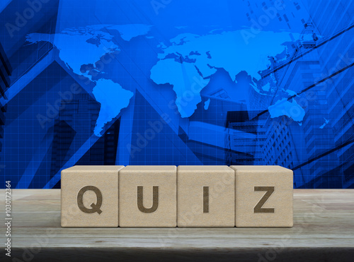 Fototapeta Naklejka Na Ścianę i Meble -  Quiz letter on wood block cubes on wooden table over world map, modern office city tower and skyscraper, Examination or test concept, Elements of this image furnished by NASA