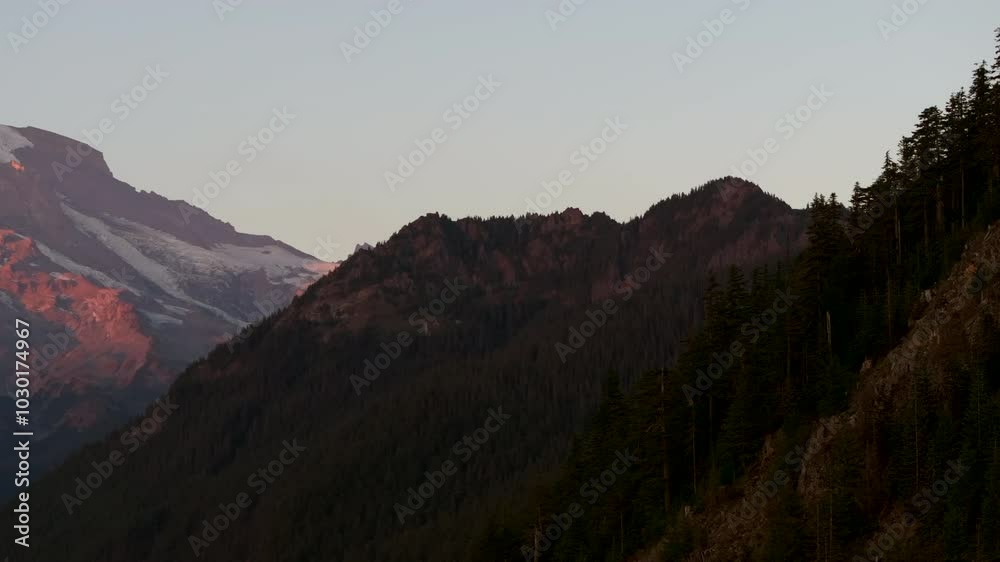 Panoramic sunset view of Mount Rainier's snow-capped slopes and rugged terrain, Washington State, USA Panoramic sunset view of Mount Rainier's snow-capped slopes and rugged terrain, Washington State, USA