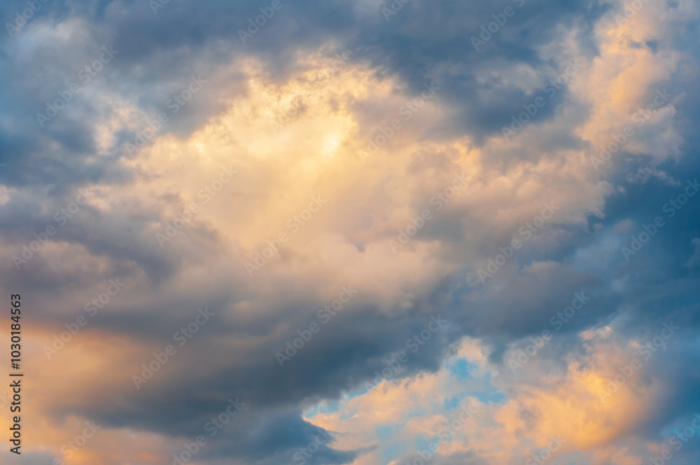 Golden and blue clouds at sunset create a dramatic sky with soft, warm lighting. Golden and blue clouds at sunset create a dramatic sky with soft, warm lighting.
