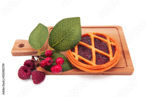 Freshly baked delicious pie with fruit filling and decorated with berries and leaveson wooden board isolated on white background. Bakery products.	 photo