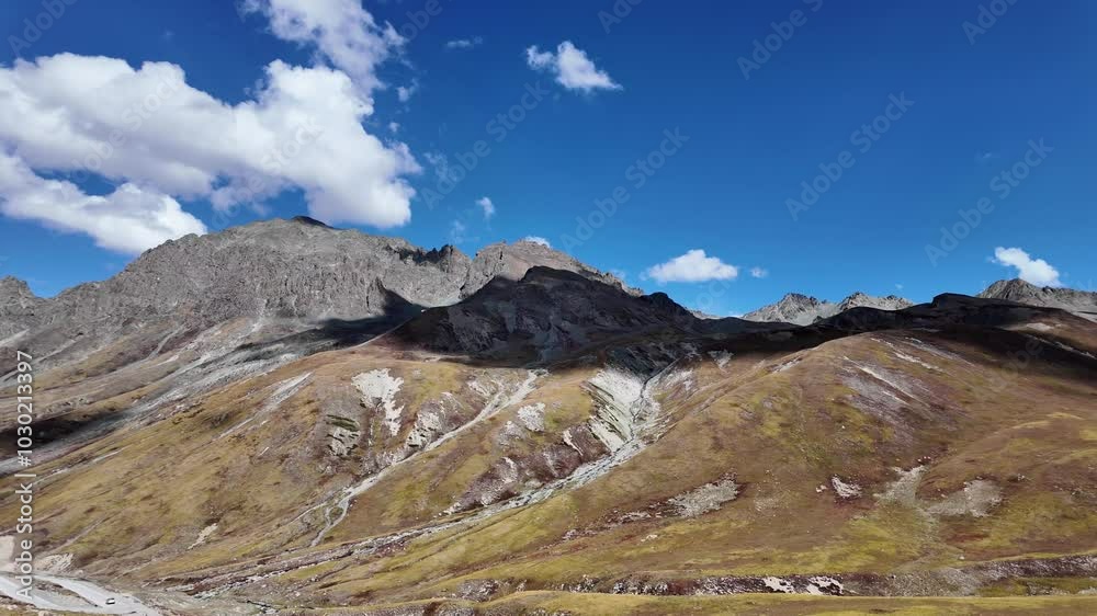 4K Mountain Landscape Side View of a Concrete Road Winding Upward Between Green Mountain Ranges, Some Parts in Shadow, Mostly Bathed in Sunlight,Beautiful Blue Sky with Cinematic Clouds 4K Mountain Landscape Side View of a Concrete Road Winding Upward Between Green Mountain Ranges, Some Parts in Shadow, Mostly Bathed in Sunlight,Beautiful Blue Sky with Cinematic Clouds