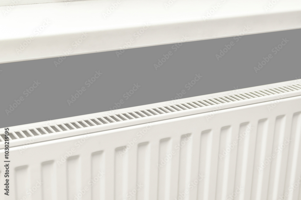 White heat battery radiator by window.Centralized heating in apartment,home in winter cold weather season, warming up. Heating prices. White heat battery radiator by window.Centralized heating in apartment,home in winter cold weather season, warming up. Heating prices.