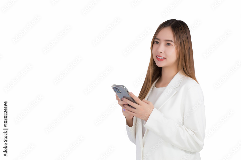 Young asian beautiful business female wearing a white suit stands while uses her smartphone to send messages to customers while isolated white background. Young asian beautiful business female wearing a white suit stands while uses her smartphone to send messages to customers while isolated white background.