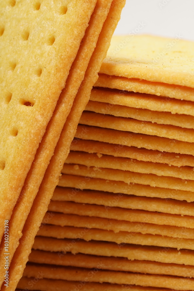 Rectangular, savory salty cheese-flavored biscuits with a golden-yellow color, neatly stacked. Perfect as a snack. Photographed on a white background. Rectangular, savory salty cheese-flavored biscuits with a golden-yellow color, neatly stacked. Perfect as a snack. Photographed on a white background.