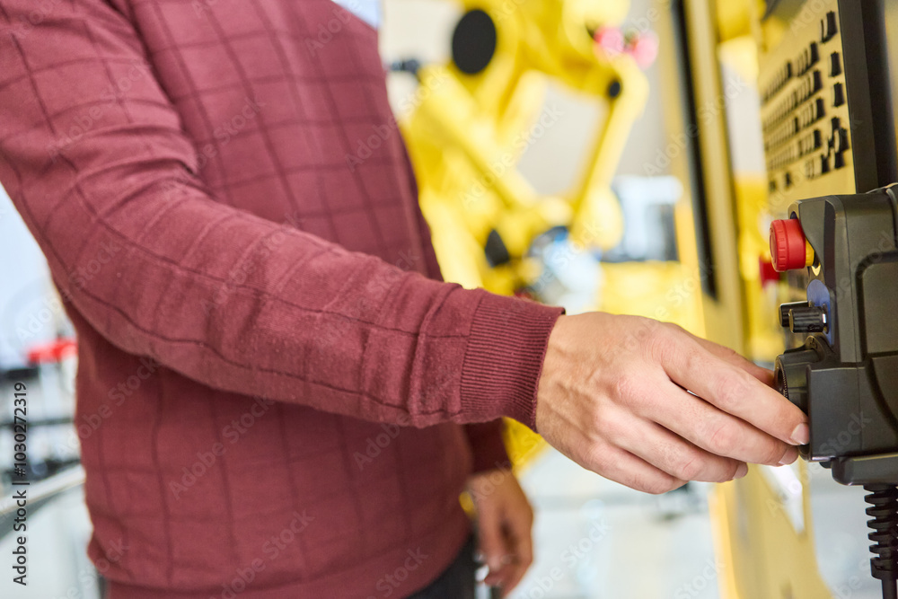 Engineer operating industrial robot machinery for automation and production Engineer operating industrial robot machinery for automation and production