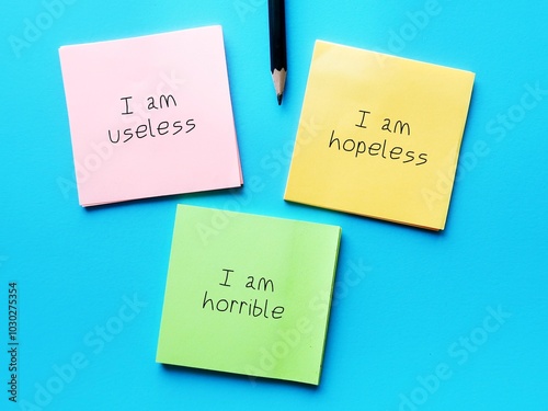 Billede på lærred Paper note on blue background written I AM HOPELESS I AM USELESS I AM HORRIBLE,