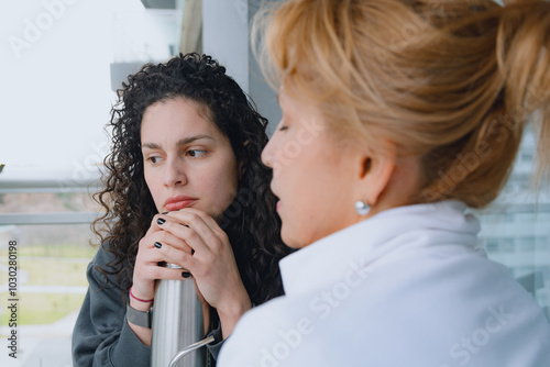 Two women, mother and daughter, are talking and reflecting together