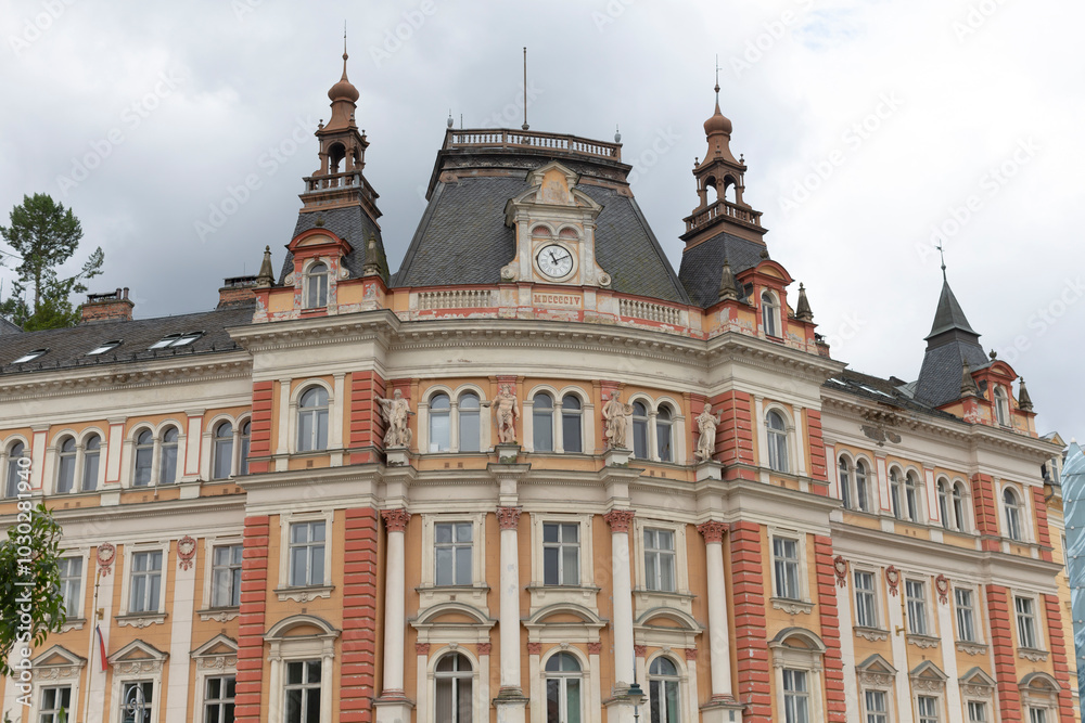 A large, impressive brick building that boasts a clock prominently positioned on the very top of its structure, showcasing its grandeur and charm A large, impressive brick building that boasts a clock prominently positioned on the very top of its structure, showcasing its grandeur and charm