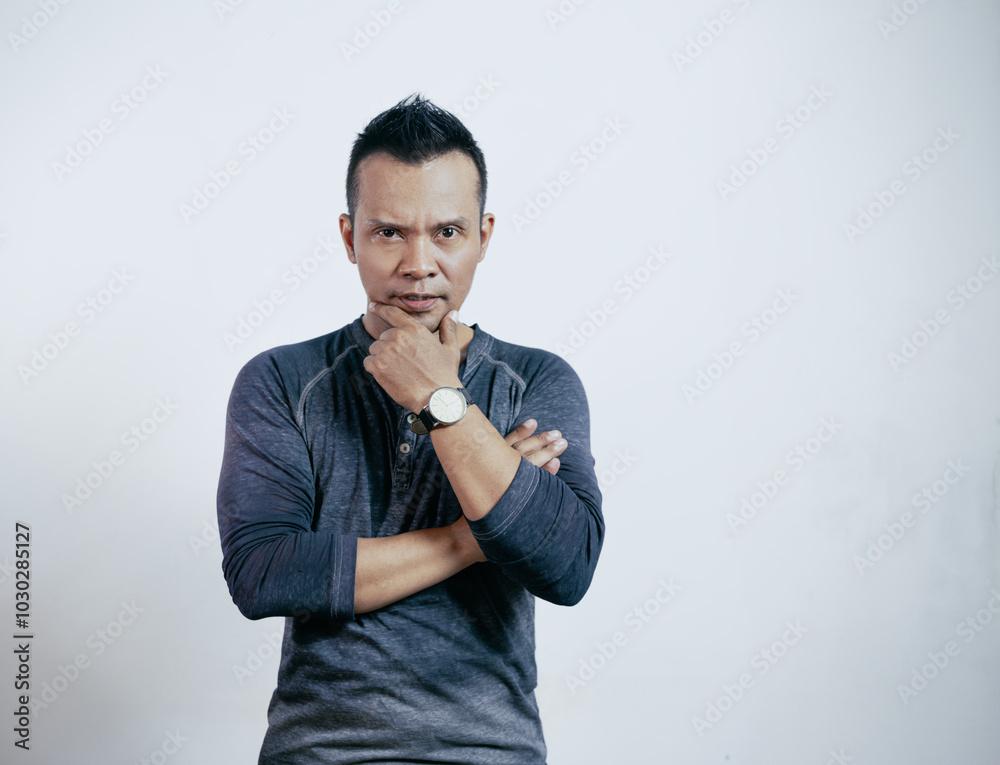 Portrait of handsome stylish asian man looking at camera, crossing arms and holding chin. Portrait of handsome stylish asian man looking at camera, crossing arms and holding chin.
