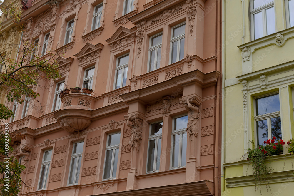 A tall building adorned with numerous windows is positioned right next to another distinctive building in the bustling urban area A tall building adorned with numerous windows is positioned right next to another distinctive building in the bustling urban area