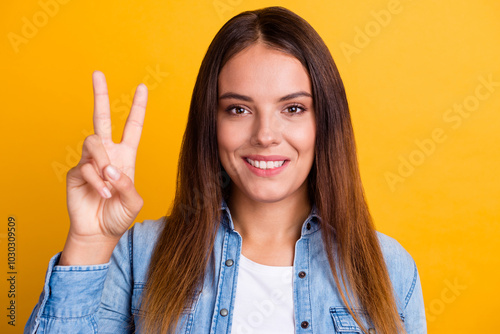 Young happy smiling satisfied positive fun eueropean caucasian student woman 20s in white casual t-shirt show victory v-sign gesture isolated on yellow color background studio portrait