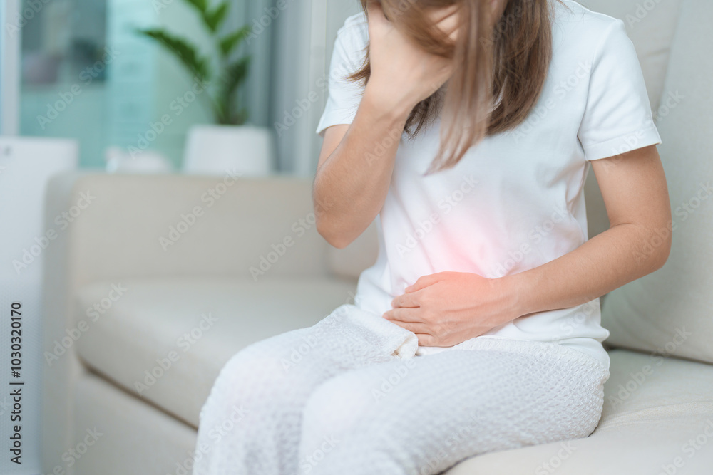 woman having abdomen ache due to Stomach pain, digestion with constipation or Diarrhea from food poisoning, female problem and Endometriosis, Hysterectomy, Stomachache and Menstrual on sofa at home woman having abdomen ache due to Stomach pain, digestion with constipation or Diarrhea from food poisoning, female problem and Endometriosis, Hysterectomy, Stomachache and Menstrual on sofa at home
