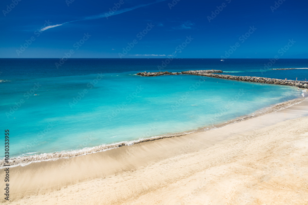 Beautiful Playa del Duque’s turquoise waters and golden shoreline sparkle under the clear blue sky on a sunny day Beautiful Playa del Duque’s turquoise waters and golden shoreline sparkle under the clear blue sky on a sunny day