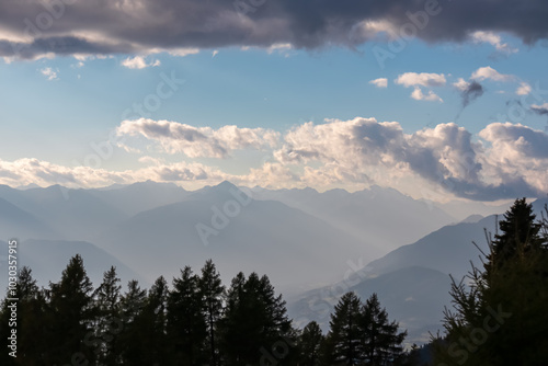 Panoramic view of majestic mountain range surrounding Lake Millstatt. Misty ridges bathed in soft light of dusk in Carinthia, Austria. Silhouette of alpine pine trees. Wanderlust Austrian Alps. Hike photo