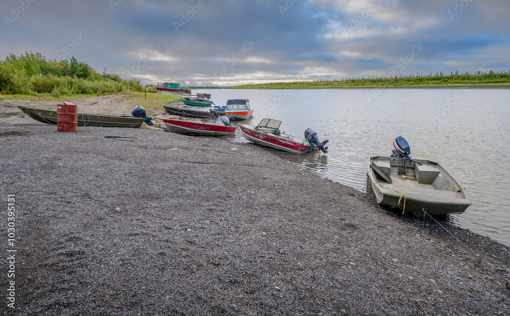 Fototapeta premium Fishing boats on the shore of the Mackenzie River at Inuvik, Northwest Territories, Canada
