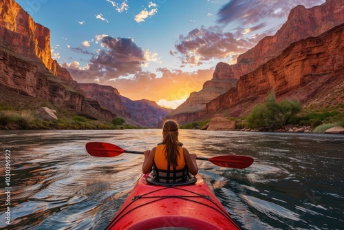 kayaking in the grand canyon at sunset, back view of woman kayaker on river with red kayak and oars,