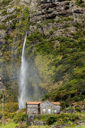 Fototapeta Naklejka Na Ścianę i Meble -  Small stone house in the mountains with waterfall next to it at Flores islamd Azores Portugal