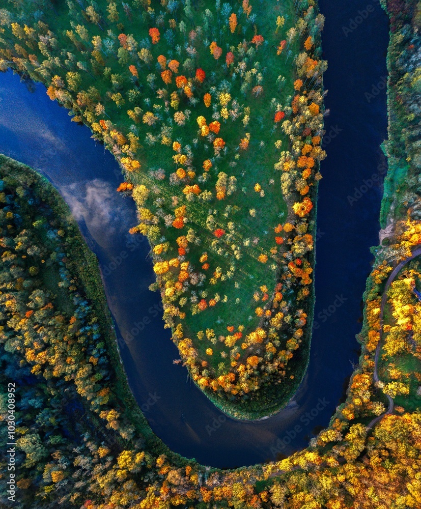 Colorful sunrise over the Gauja National park valley. Sigulda city panorama from drone with forest in autumn colors.