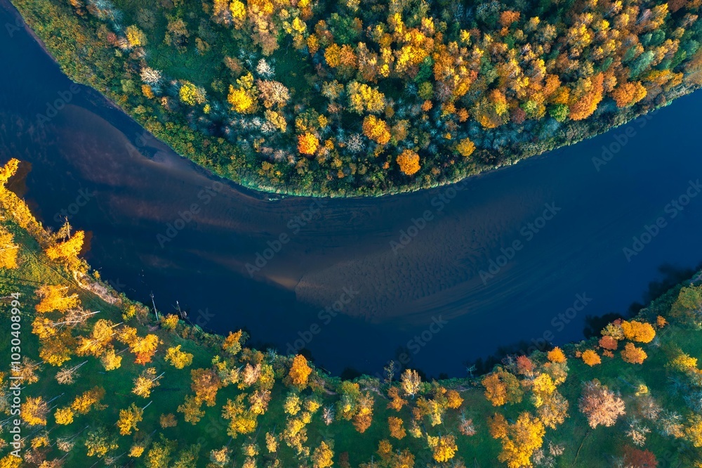 Colorful sunrise over the Gauja National park valley. Sigulda city panorama from drone with forest in autumn colors.