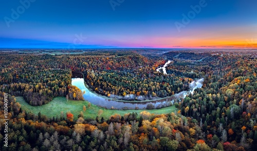 Obraz na płótnie Colorful sunrise over the Gauja National park valley. Sigulda city panorama from drone with forest in autumn colors. w salonie
